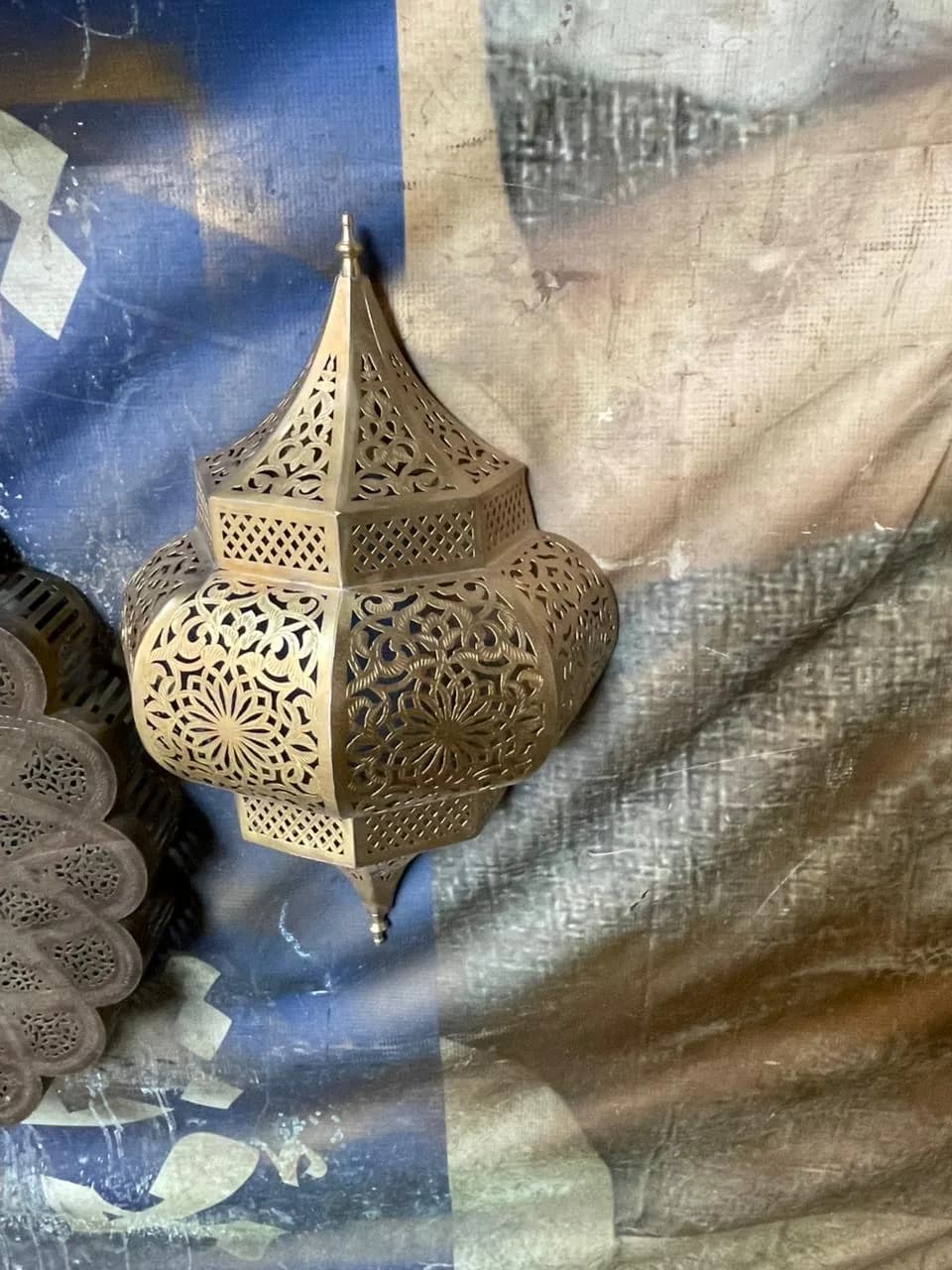 An unlit pierced brass wall lantern with a domed top and star-pattern panels